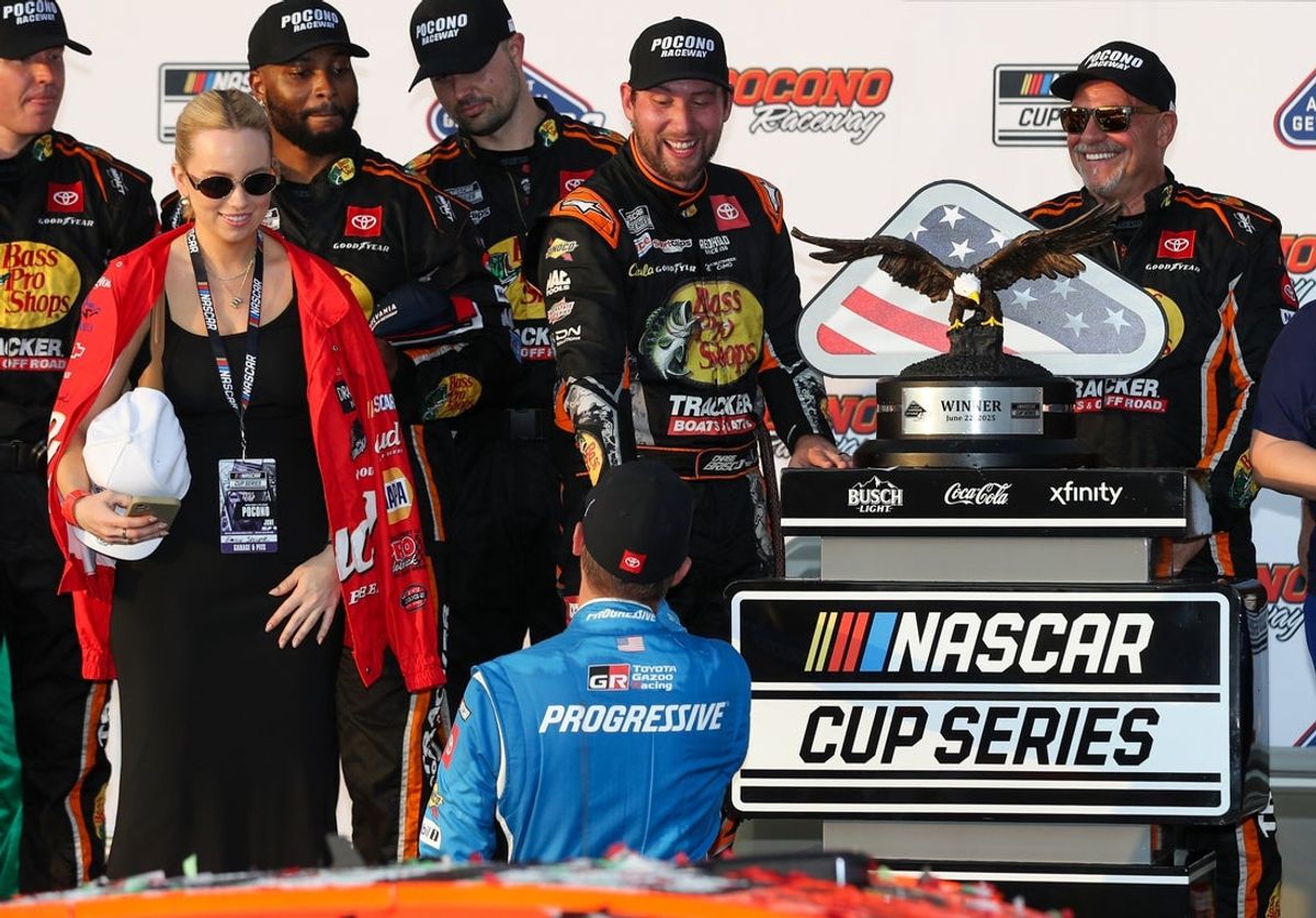 Jun 22, 2025; Long Pond, Pennsylvania, USA; NASCAR Cup Series driver Chase Briscoe is congratulated in victory lane by driver Denny Hamlin after winning The Great American Getaway 400 at Pocono Raceway. Mandatory Credit: Matthew O'Haren-Imagn Images