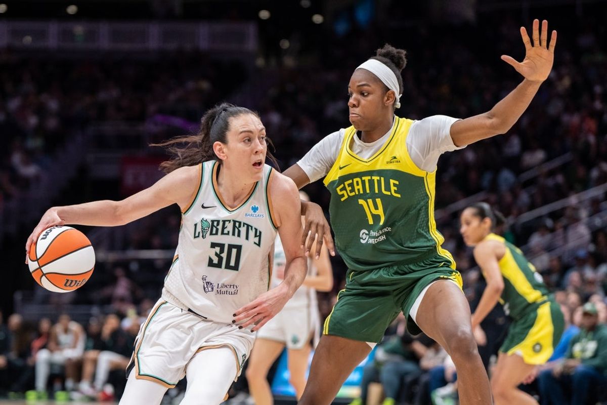Jun 22, 2025; Seattle, Washington, USA;  New York Liberty forward Breanna Stewart (30) dribbles the ball against Seattle Storm center Dominique Malonga (14) during the second half at Climate Pledge Arena. Mandatory Credit: Stephen Brashear-Imagn Images