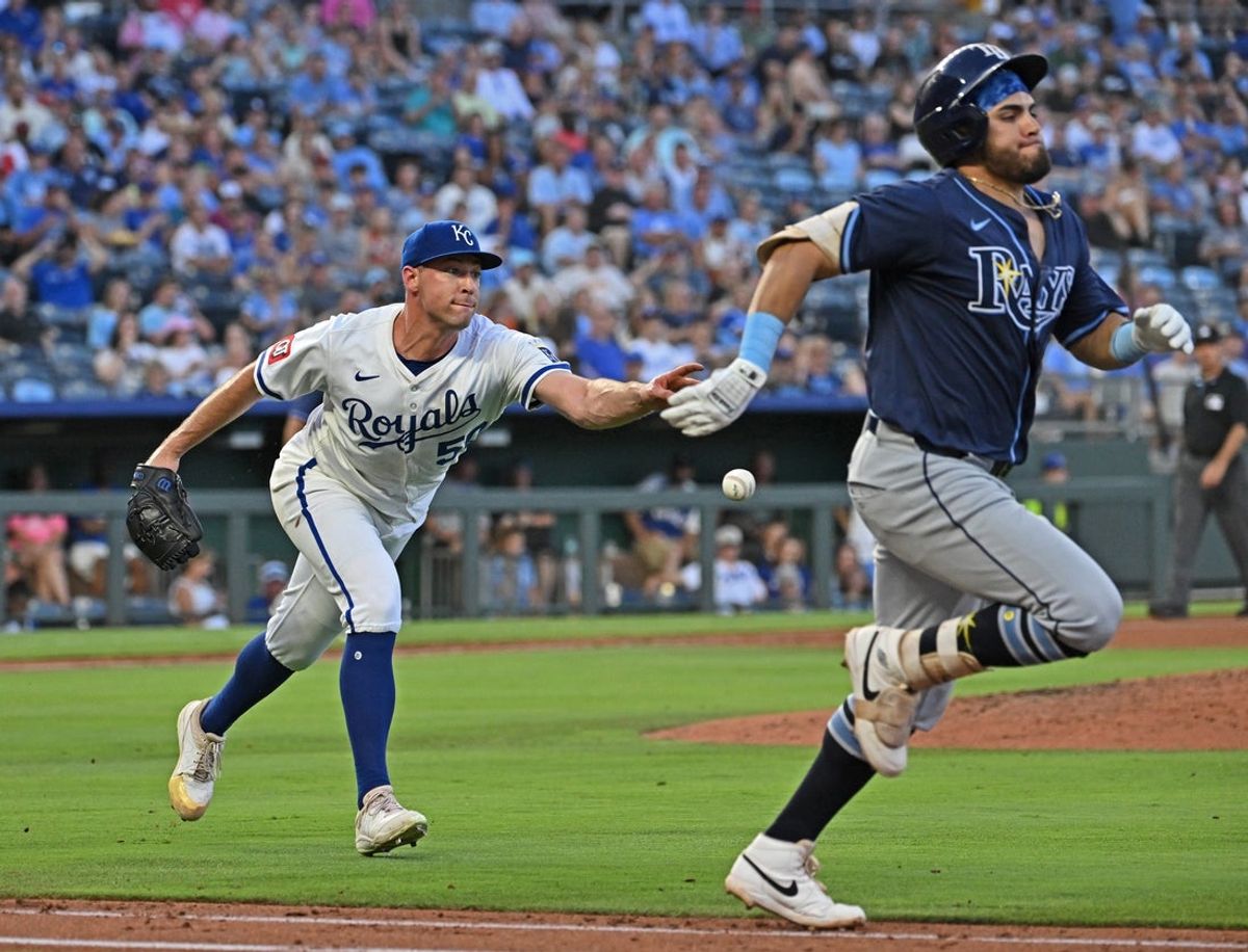 Jun 24, 2025; Kansas City, Missouri, USA;  Kansas City Royals starting pitcher Kris Bubic (50) tosses the ball to first base, with Tampa Bay Rays designated hitter Jonathan Aranda (62) running up the first base line in the fifth inning at Kauffman Stadium. Mandatory Credit: Peter Aiken-Imagn Images