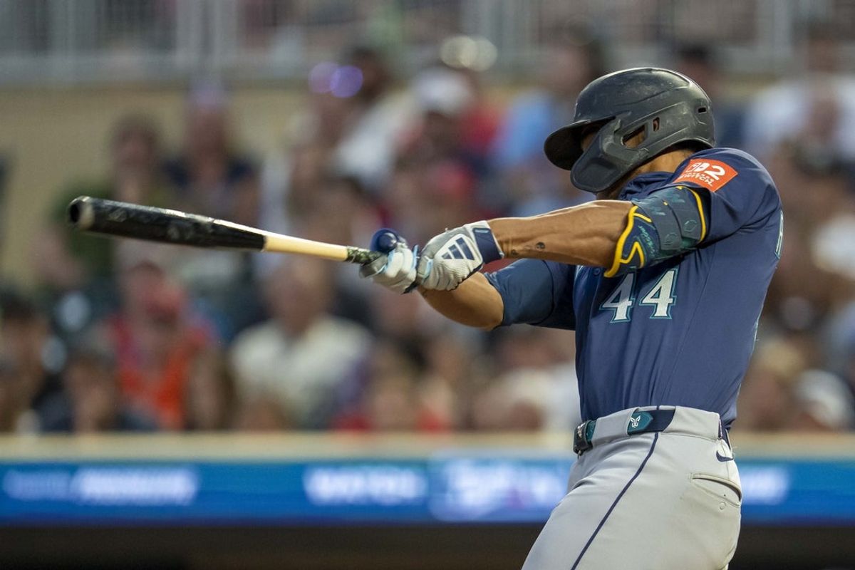 Jun 24, 2025; Minneapolis, Minnesota, USA; Seattle Mariners center fielder Julio Rodriguez (44) hits an RBI sacrifice fly ball against the Minnesota Twins in the ninth inning at Target Field. Mandatory Credit: Jesse Johnson-Imagn Images
