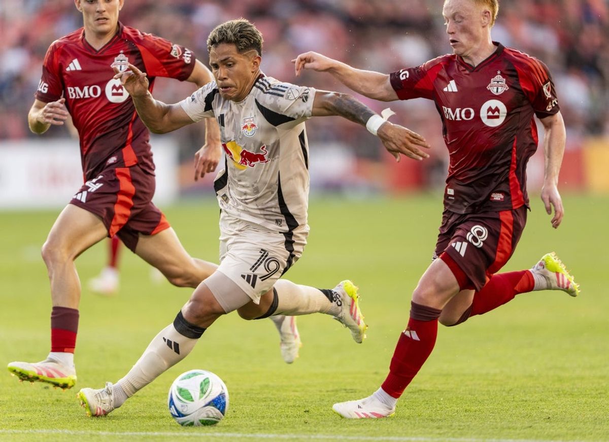 Jun 25, 2025; Toronto, Ontario, CAN; New York Red Bulls midfielder Wikelman Carmona (19) moves the ball against Toronto FC midfielder Matty Longstaff (8) during the first half at BMO Field. Mandatory Credit: Kevin Sousa-Imagn Images