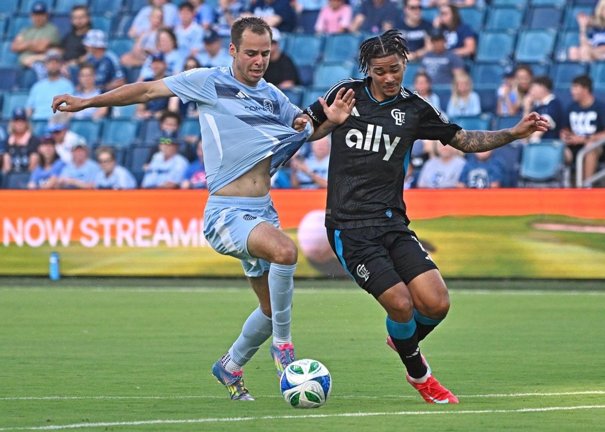 Jun 25, 2025; Kansas City, Kansas, USA;  Sporting Kansas City defender Jansen Miller (15) dribbles the ball against Charlotte FC forward Idan Toklomati (17) in the first half at Children's Mercy Park. Mandatory Credit: Peter Aiken-Imagn Images