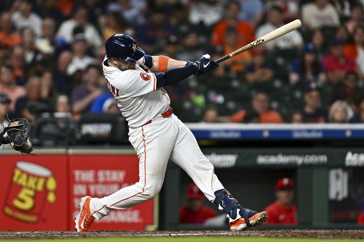 Jun 25, 2025; Houston, Texas, USA; Houston Astros catcher Victor Caratini (17) hits a solo home run in the eighth inning against the Philadelphia Phillies at Daikin Park. Mandatory Credit: Maria Lysaker-Imagn Images