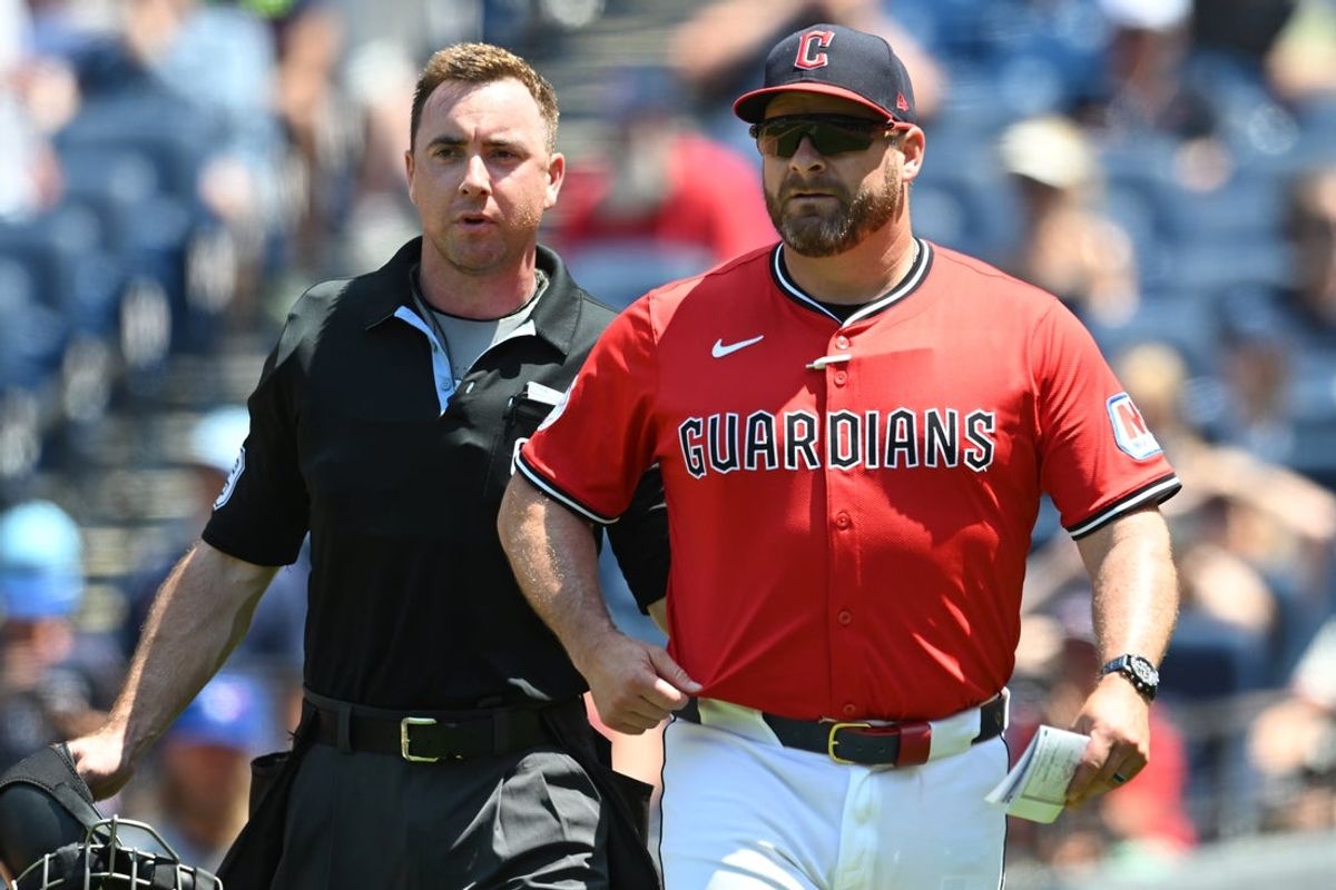 Jun 26, 2025; Cleveland, Ohio, USA; Home plate umpire Tom Hanahan walks Cleveland Guardians manager Stephen Vogt (12) back to the dugout during the fifth inning against the Toronto Blue Jays at Progressive Field. Mandatory Credit: Ken Blaze-Imagn Images