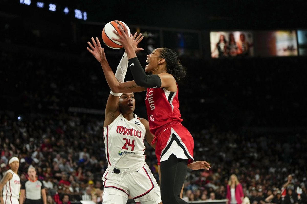 Jun 26, 2025; Las Vegas, Nevada, USA;  Las Vegas center A'ja Wilson (22) attempts to score a layup against Washington Mystics forward Aaliyah Edwards (24) during the first half of a WNBA basketball game at Michelob Ultra Arena. Mandatory Credit: Lucas Peltier-Imagn Images
