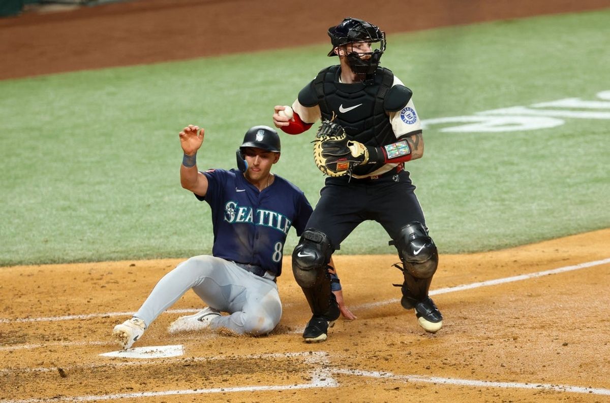 Jun 27, 2025; Arlington, Texas, USA;  Texas Rangers catcher Jonah Heim (28) forces out Seattle Mariners right fielder Dominic Canzone (8) at home plate during the fourth inning at Globe Life Field. Mandatory Credit: Kevin Jairaj-Imagn Images
