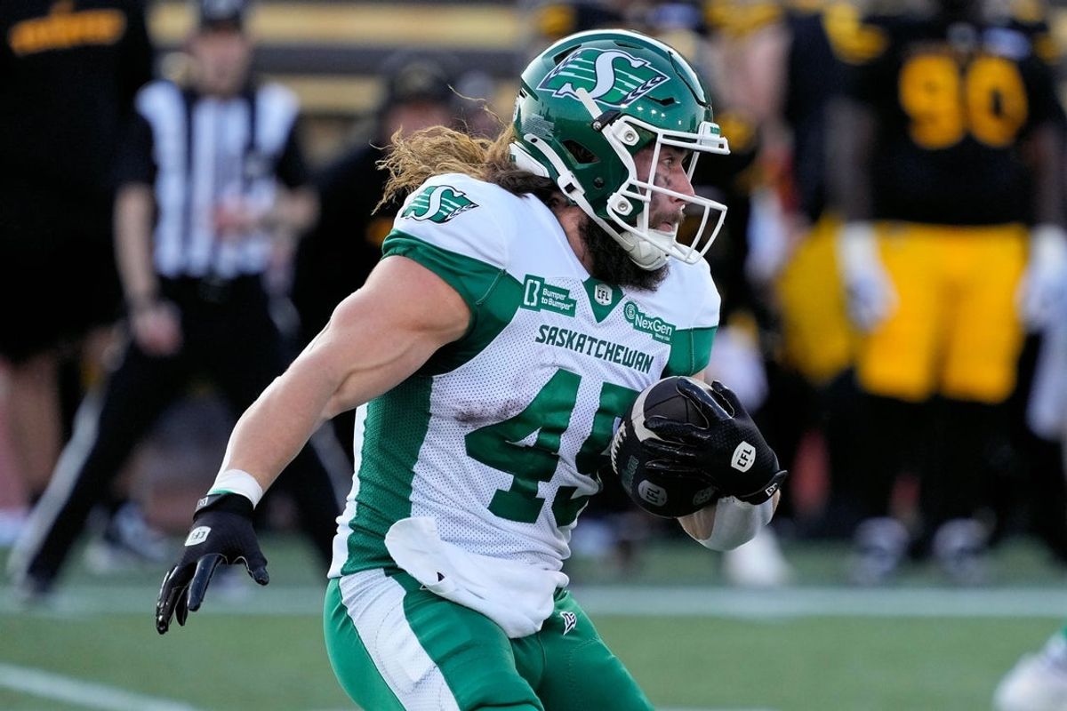 Jun 14, 2025; Hamilton, Ontario, Canada; Saskatchewan Roughriders running back A.J. Ouellette (45) rushes with the football against the Hamilton Tiger-Cats at Hamilton Stadium. Mandatory Credit: John E. Sokolowski-Imagn Images