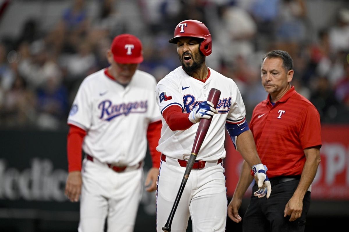 Jun 28, 2025; Arlington, Texas, USA; Texas Rangers second baseman Marcus Semien (2) reacts after he is hit by a foul tip ball off his bat during the fifth inning against the Seattle Mariners at Globe Life Field. Mandatory Credit: Jerome Miron-Imagn Images