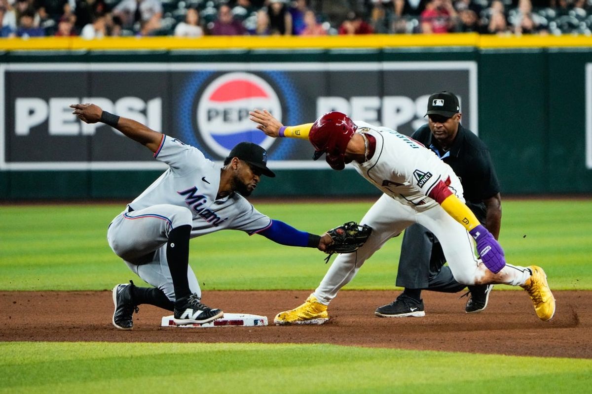 Jun 28, 2025; Phoenix, Arizona, USA; Miami Marlins second baseman Otto Lopez (6) tags Arizona Diamondbacks outfielder Lourdes Gurriel Jr. (12) out at second base in the seventh inning at Chase Field. Mandatory Credit: Arianna Grainey-Imagn Images