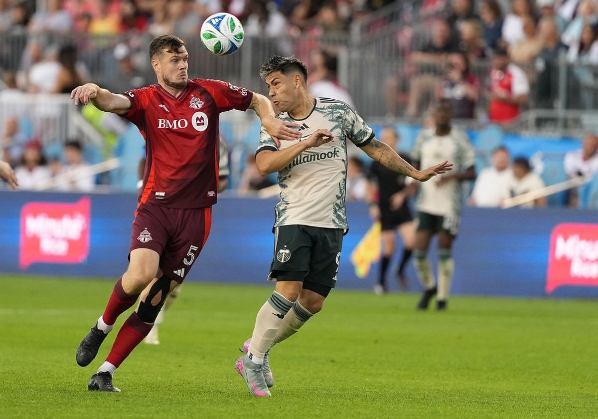 Jun 28, 2025; Toronto, Ontario, CAN; Toronto FC defender Kevin Long (5) battles for the ball with Portland Timbers forward Felipe Mora (9) during the second half at BMO Field. Mandatory Credit: Nick Turchiaro-Imagn Images