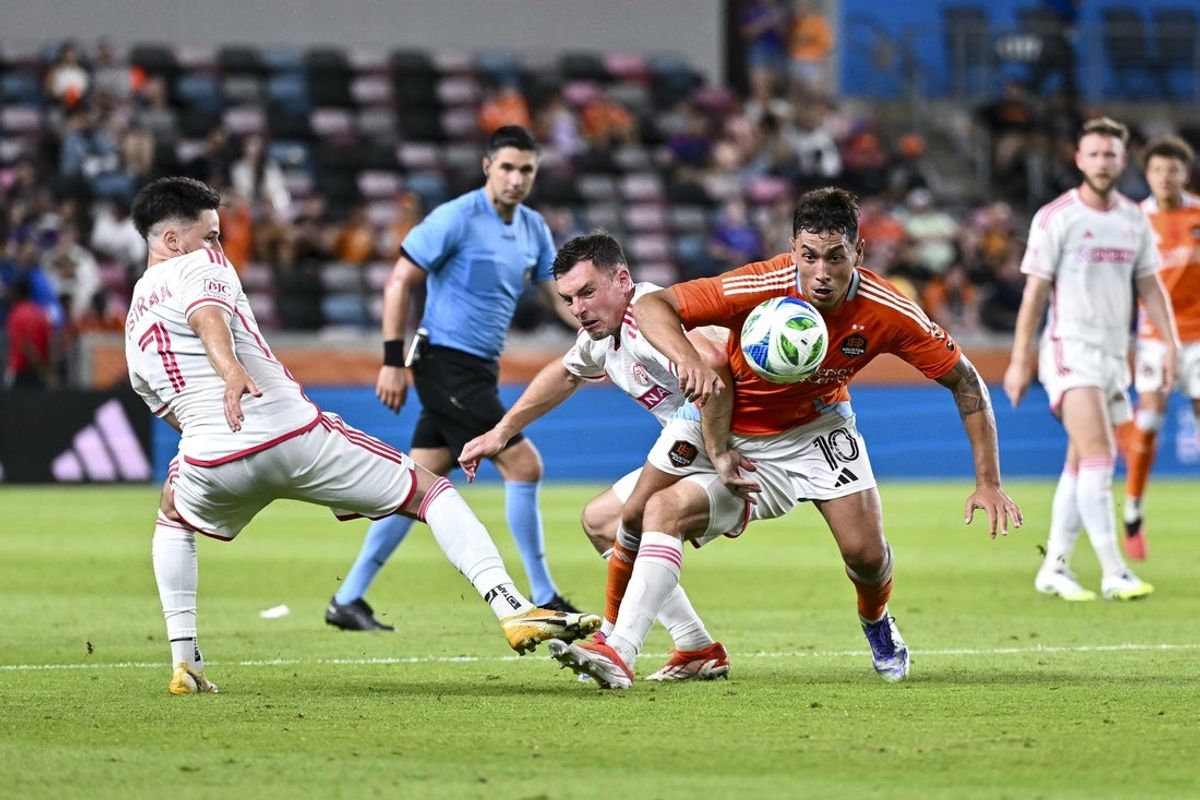 Jun 28, 2025; Houston, Texas, USA; Houston Dynamo forward Ezequiel Ponce (10) controls the ball around St. Louis City midfielder Celio Pompeu (12) and forward Tomas Ostrak (7) during the second half at Shell Energy Stadium. Mandatory Credit: Maria Lysaker-Imagn Images