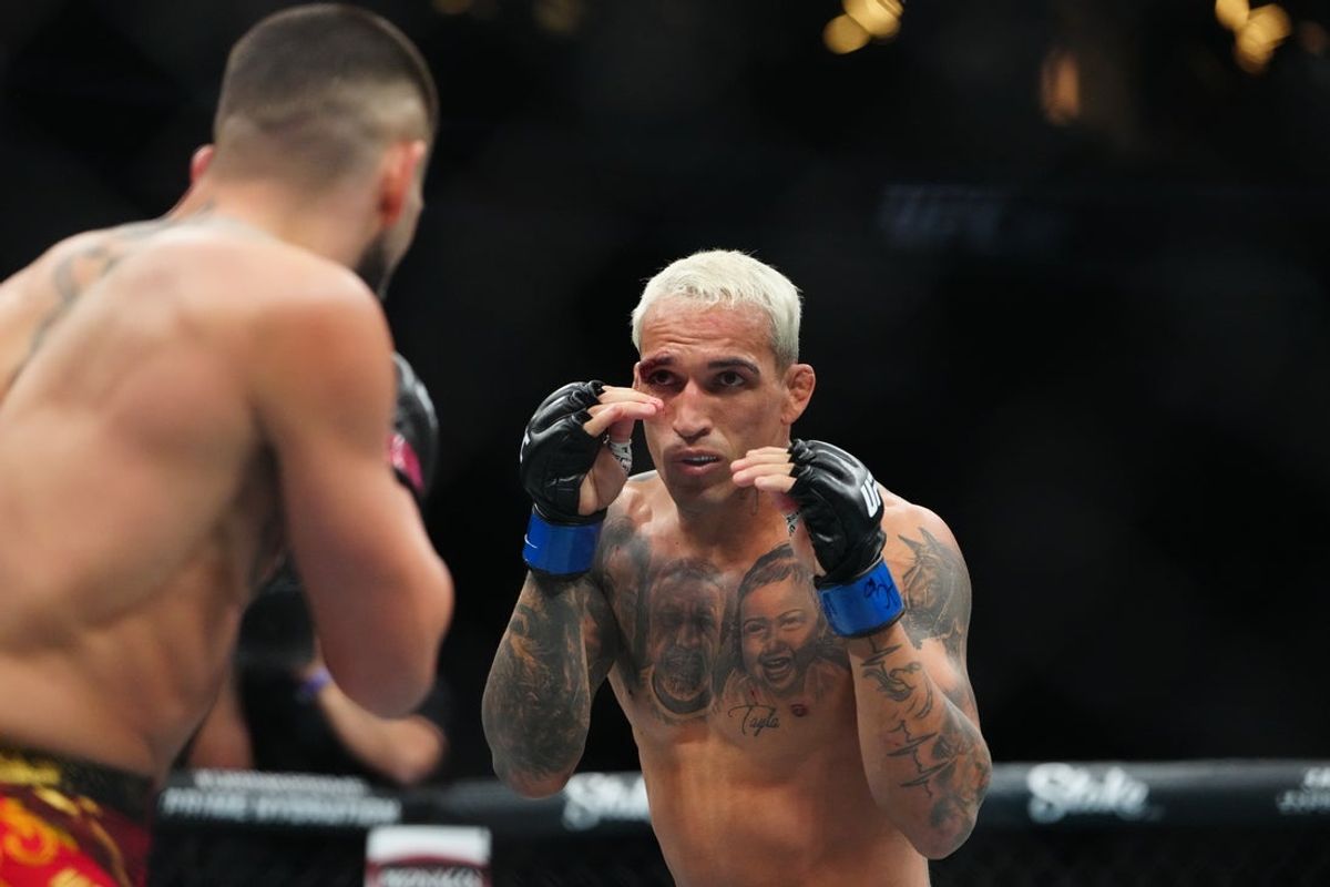 Jun 28, 2025; Las Vegas, Nevada, USA; Ilia Topuria (red gloves) fights Charles Oliveira (blue gloves) during UFC 317 at T-Mobile Arena. Mandatory Credit: Stephen R. Sylvanie-Imagn Images