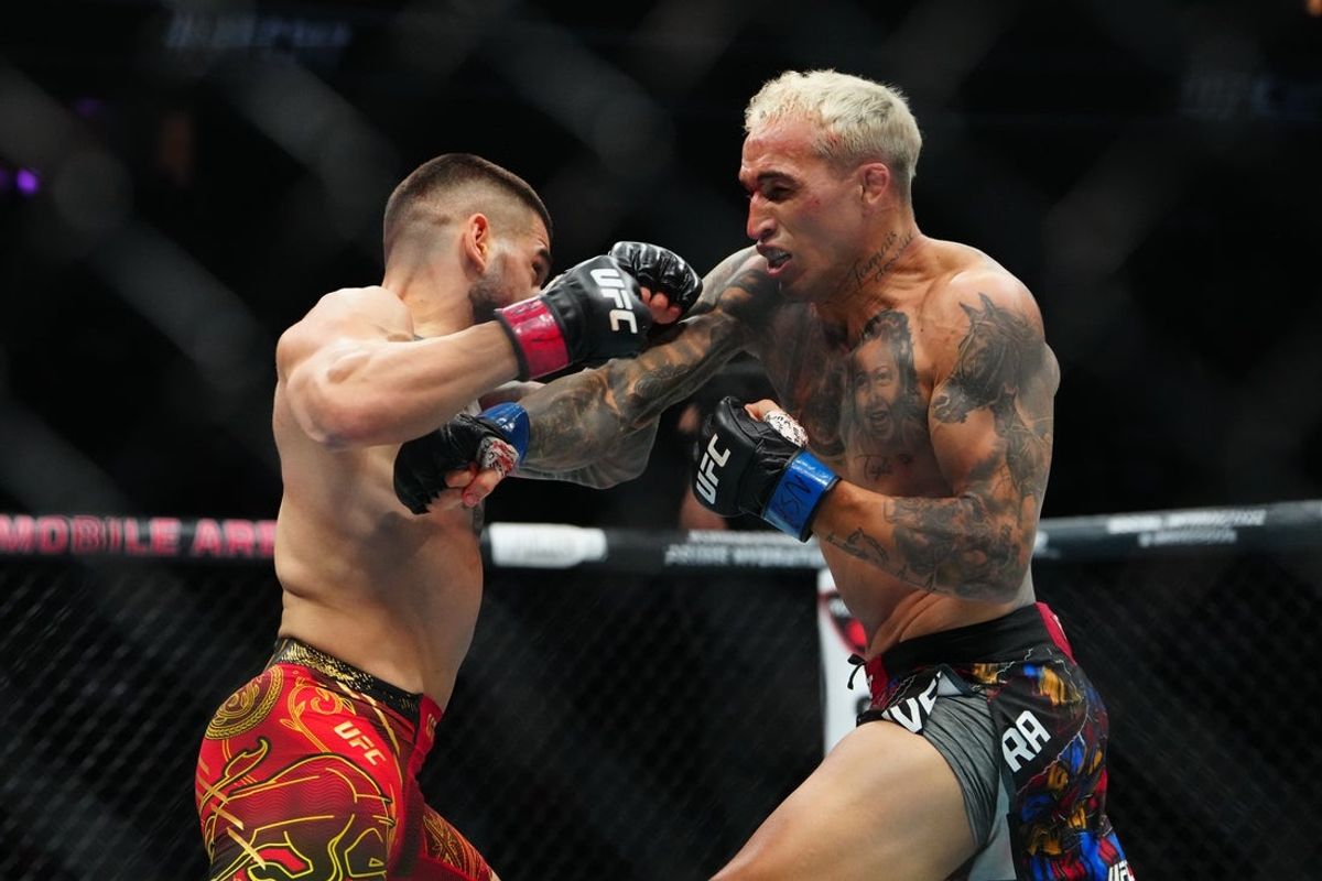 Jun 28, 2025; Las Vegas, Nevada, USA; Ilia Topuria (red gloves) fights Charles Oliveira (blue gloves) during UFC 317 at T-Mobile Arena. Mandatory Credit: Stephen R. Sylvanie-Imagn Images