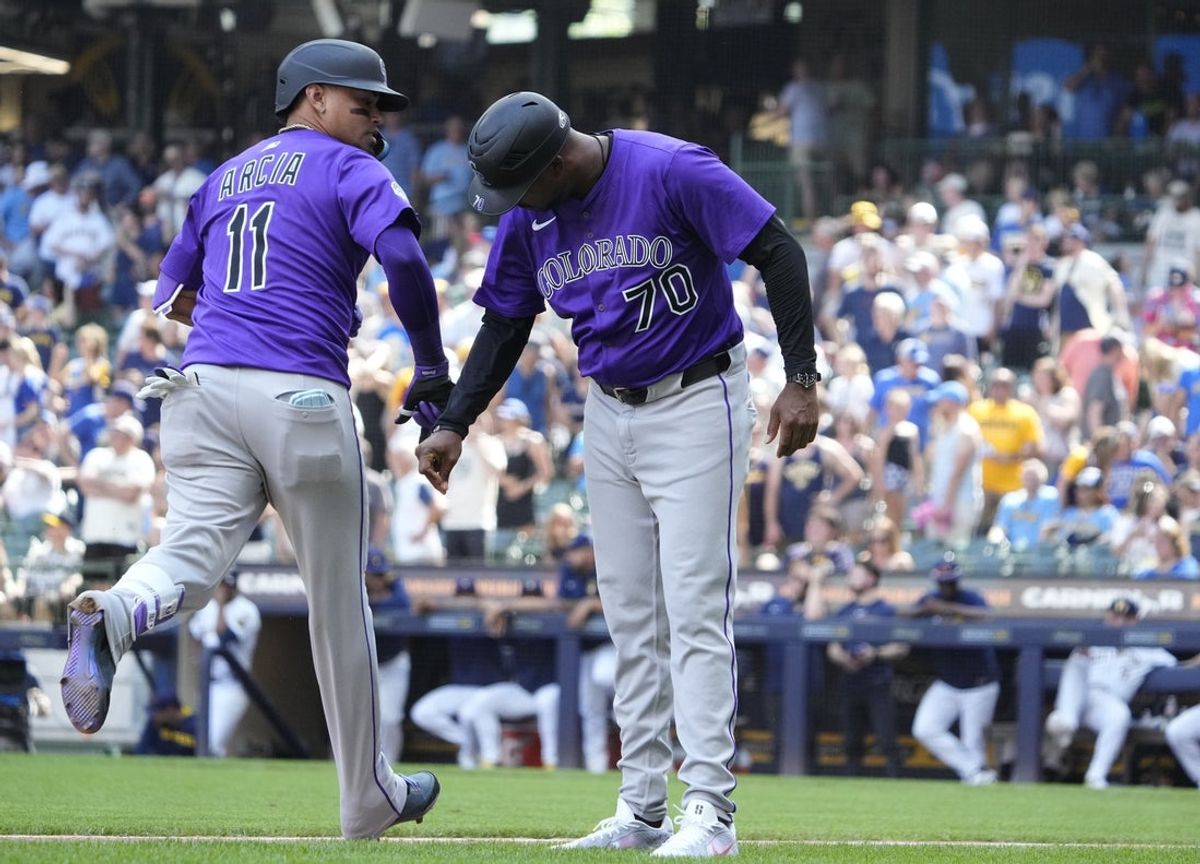 Jun 29, 2025; Milwaukee, Wisconsin, USA; Colorado Rockies third base coach Andy González (70) congratulates shortstop Orlando Arcia (11) after hitting a home run against the Milwaukee Brewers in the ninth inning at American Family Field. Mandatory Credit: Michael McLoone-Imagn Images