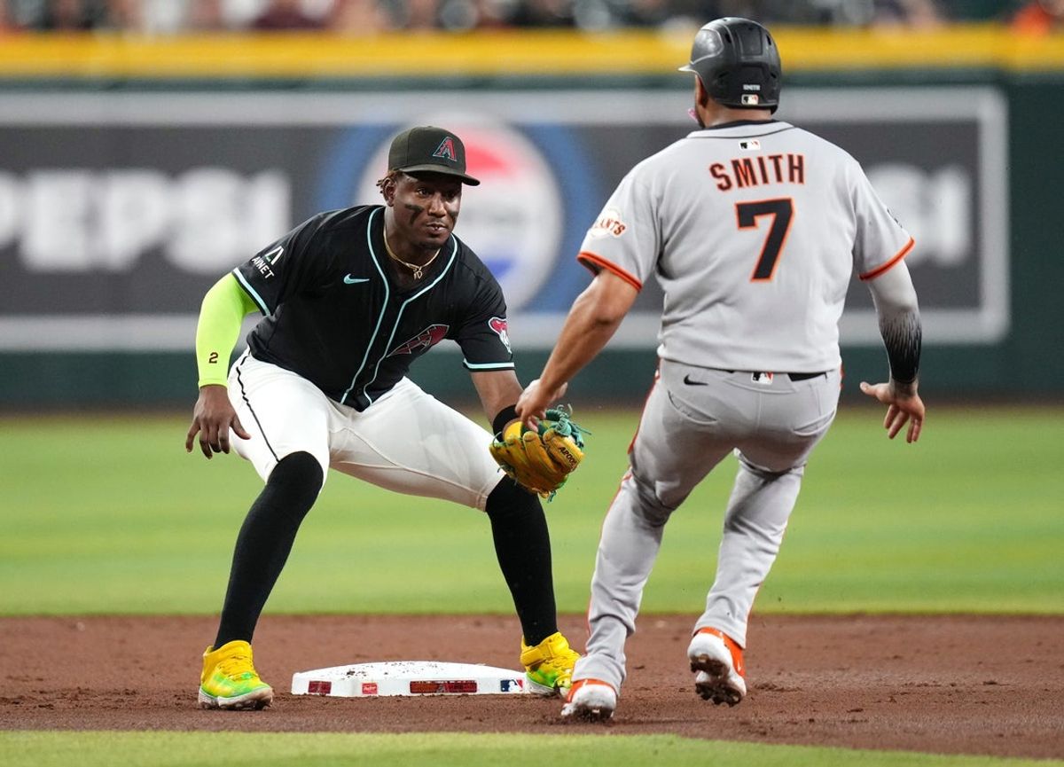 Arizona Diamondbacks infielder Geraldo Perdomo (2) tags out San Francisco Giants base runner Dominic Smith (7) at Chase Field on June 30, 2025.