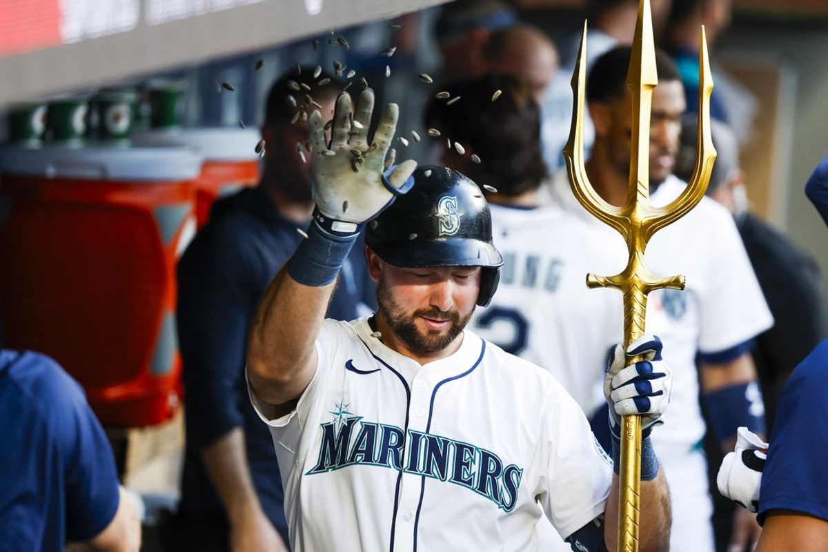 Jun 30, 2025; Seattle, Washington, USA; Seattle Mariners catcher Cal Raleigh (29) swats away sunflower seeds thrown by a teammate in the dugout after hitting a solo-home run against the Kansas City Royals during the seventh inning at T-Mobile Park. Mandatory Credit: Joe Nicholson-Imagn Images