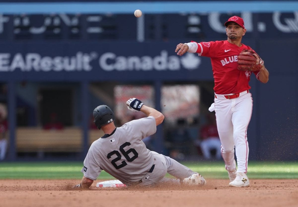 Jul 1, 2025; Toronto, Ontario, CAN; Toronto Blue Jays second baseman Andre Gimenez (0) forces out New York Yankees second baseman DJ LeMahieu (26) during the sixth inning at Rogers Centre. Mandatory Credit: Nick Turchiaro-Imagn Images