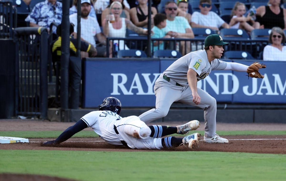 Jul 1, 2025; St. Petersburg, Florida, USA; Tampa Bay Rays outfielder Jose Caballero (77) steals third base as Athletics third base Max Muncy (10) attempted to tag him out during the second inning  at George M. Steinbrenner Field. Mandatory Credit: Kim Klement Neitzel-Imagn Images
