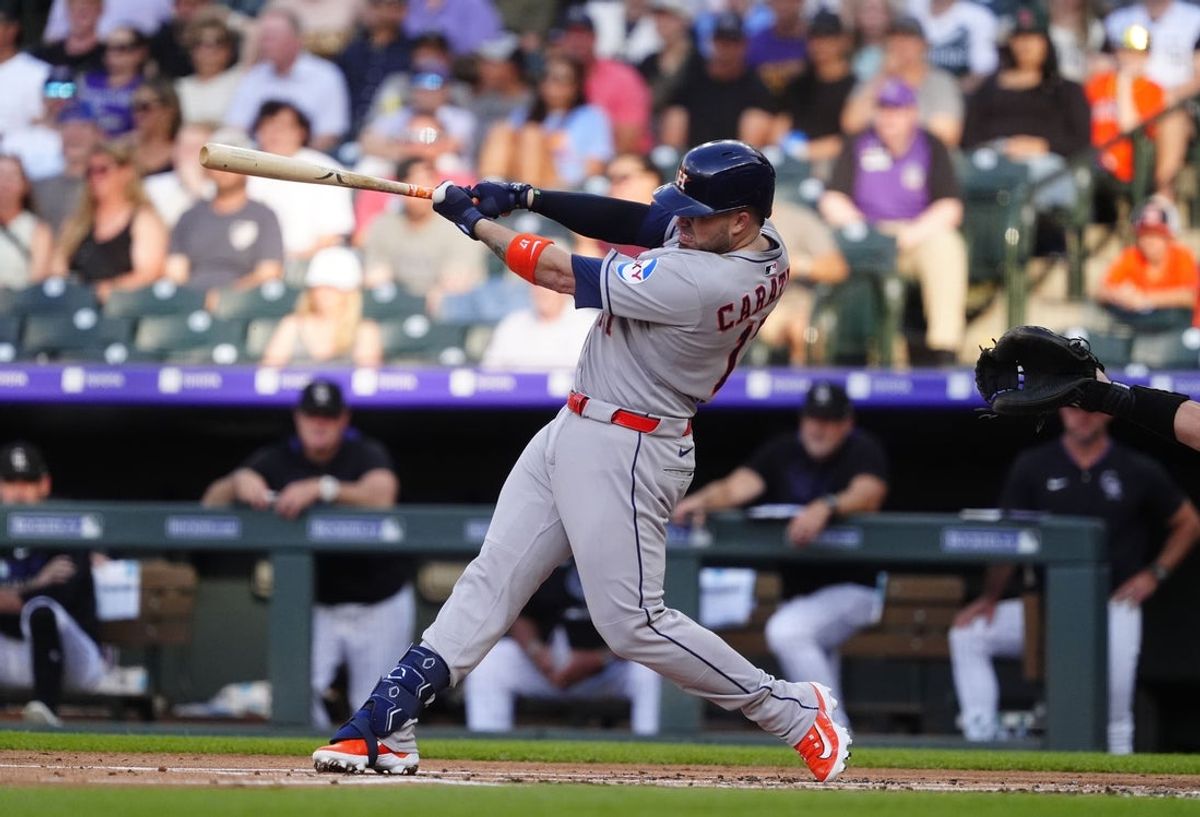 Jul 1, 2025; Denver, Colorado, USA; Houston Astros catcher Victor Caratini (17) singles in the second inning against the Colorado Rockies at Coors Field. Mandatory Credit: Ron Chenoy-Imagn Images