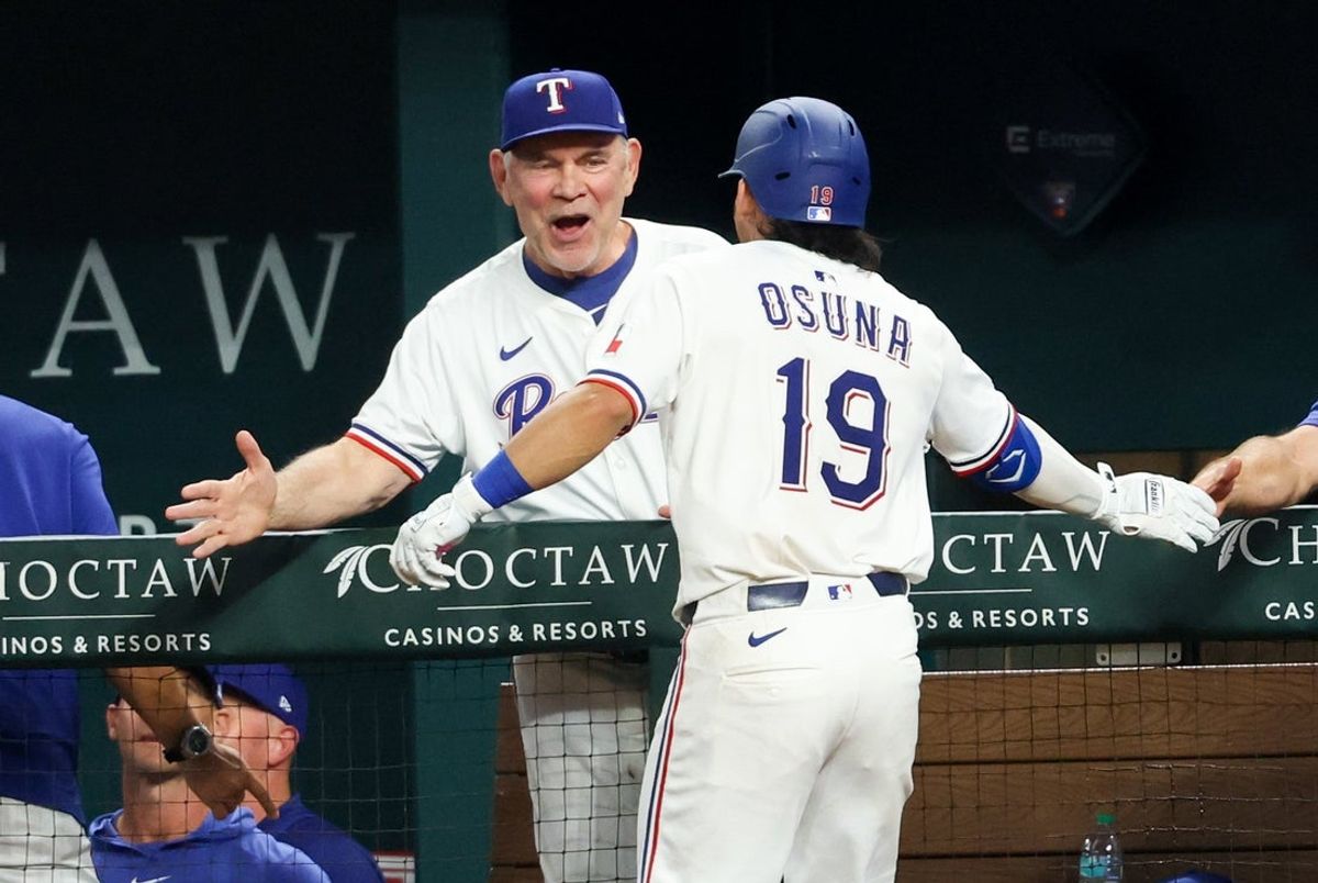 Jul 1, 2025; Arlington, Texas, USA;  Texas Rangers left fielder Alejandro Osuna (19) celebrates his first MLB homer with Texas Rangers manager Bruce Bochy (15) after hitting a two-run shot during the fifth inning against the Baltimore Orioles at Globe Life Field. Mandatory Credit: Kevin Jairaj-Imagn Images