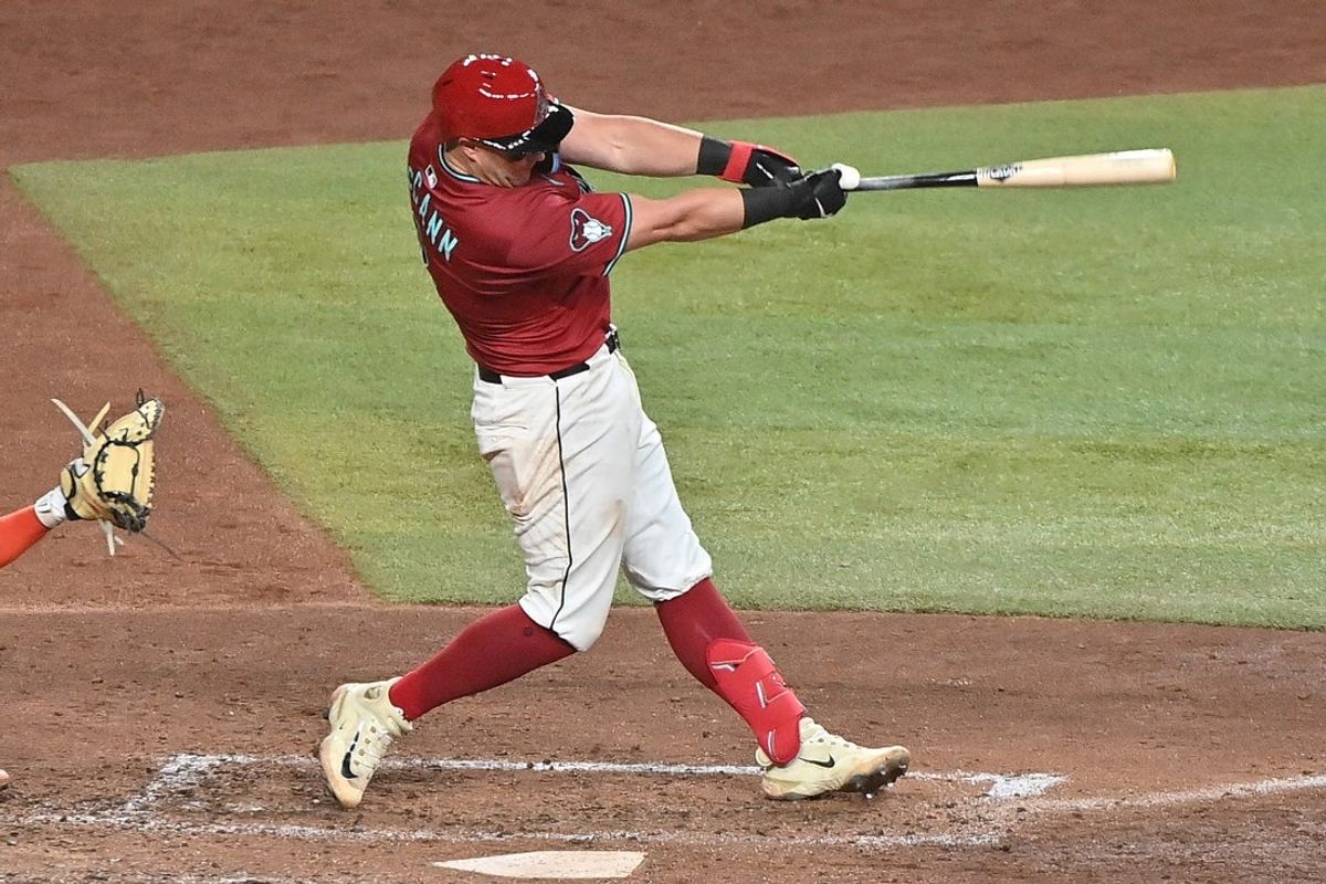 Jul 1, 2025; Phoenix, Arizona, USA; Arizona Diamondbacks catcher James McCann (8) hits a solo home run in the sixth inning against the San Francisco Giants  at Chase Field. Mandatory Credit: Matt Kartozian-Imagn Images
