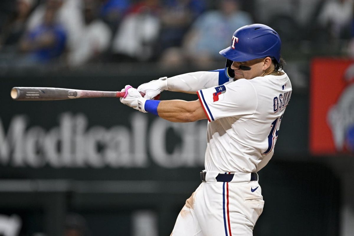 Jul 2, 2025; Arlington, Texas, USA; Texas Rangers left fielder Alejandro Osuna (19) hits a single against the Baltimore Orioles during the fifth inning at Globe Life Field. Mandatory Credit: Jerome Miron-Imagn Images
