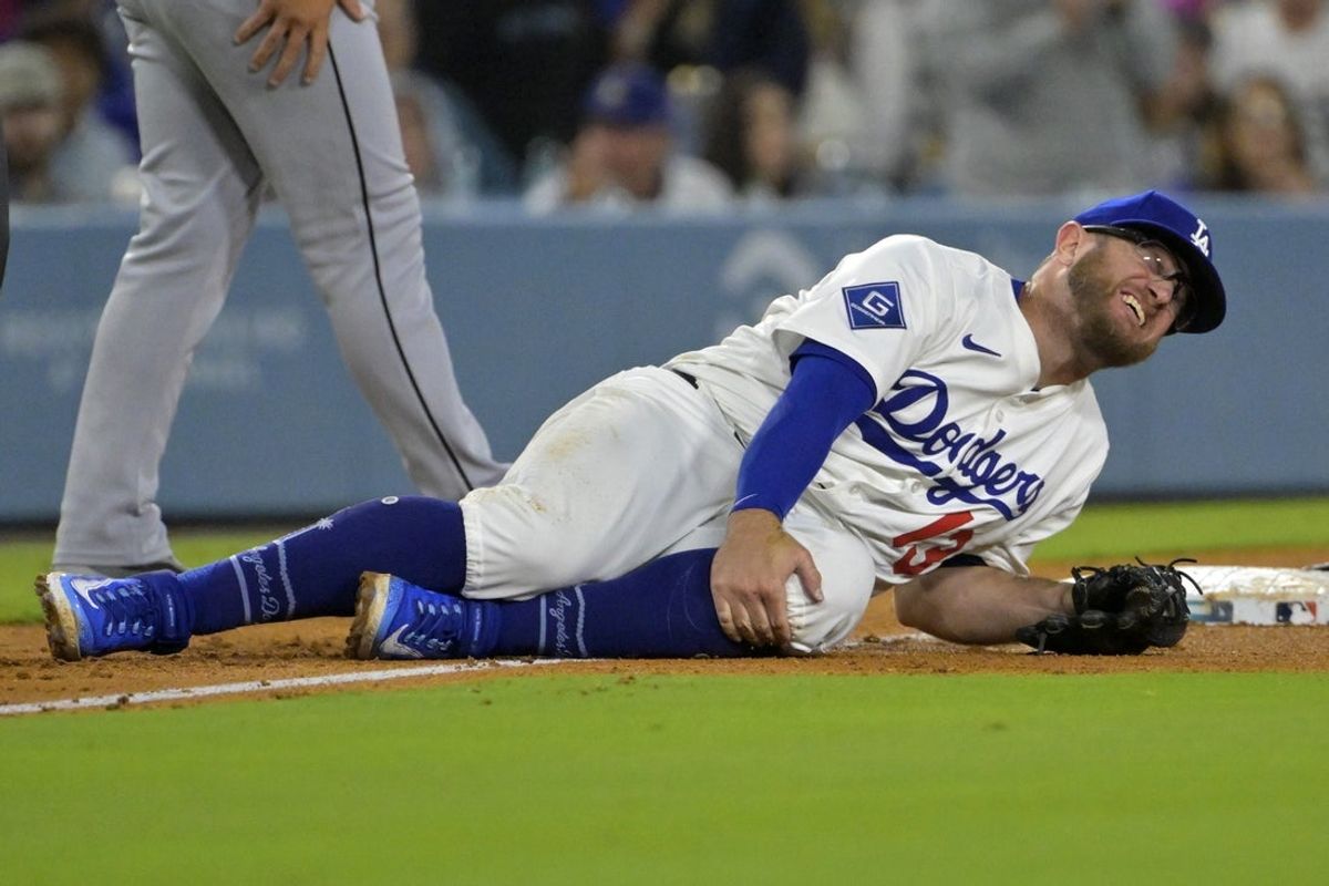 Jul 2, 2025; Los Angeles, California, USA;  Los Angeles Dodgers third baseman Max Muncy (13) grabs his knee after tagging Chicago White Sox right fielder Michael A. Taylor (21) out on an attempted stolen base during the fifth inning at Dodger Stadium. Mandatory Credit: Jayne Kamin-Oncea-Imagn Images