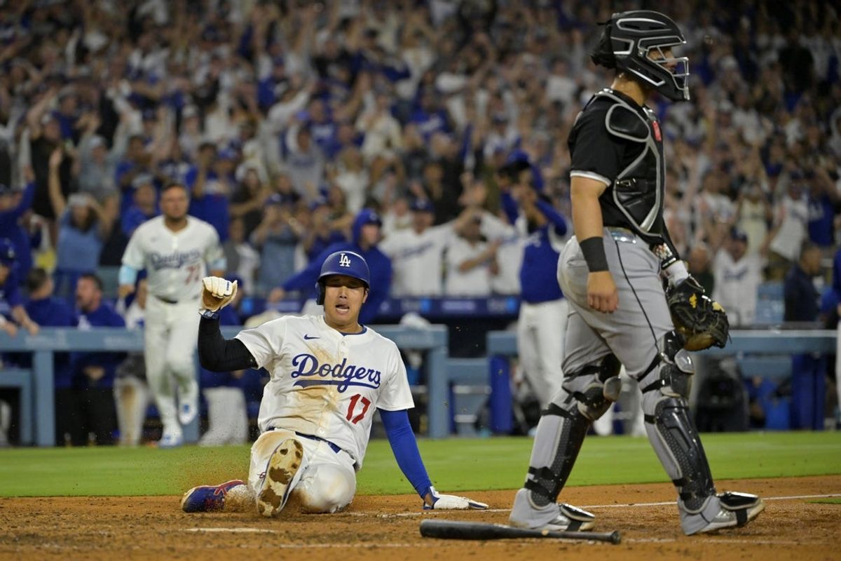 Jul 2, 2025; Los Angeles, California, USA;  Chicago White Sox catcher Edgar Quero (7) walks off the field as Los Angeles Dodgers designated hitter Shohei Ohtani (17) scores the winning run on a walk-off single by first baseman Freddie Freeman (5) during the ninth inning at Dodger Stadium. Mandatory Credit: Jayne Kamin-Oncea-Imagn Images