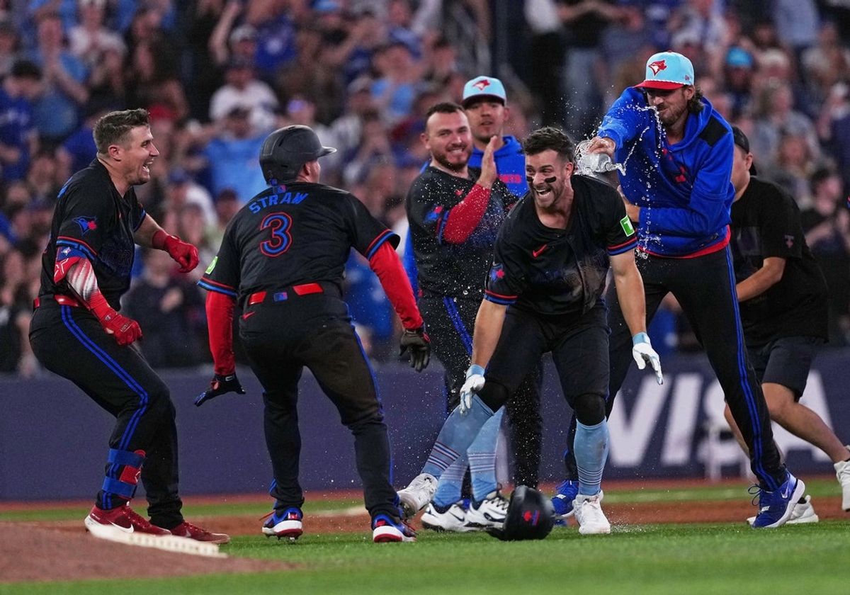 Jul 4, 2025; Toronto, Ontario, CAN; Toronto Blue Jays third baseman Ernie Clement (22) celebrates the win with outfielder Myles Straw (3) against the Los Angeles Angels during  the tenth inning at Rogers Centre. Mandatory Credit: Nick Turchiaro-Imagn Images