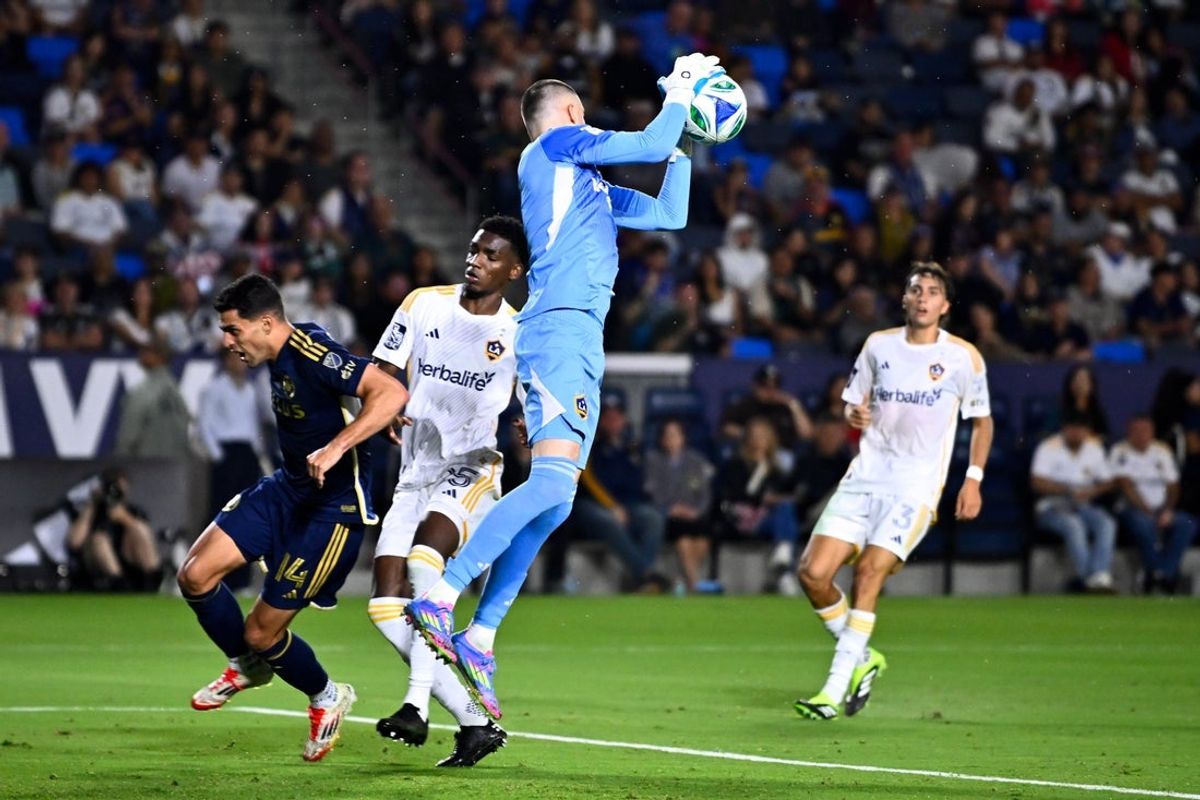 Jul 4, 2025; Carson, California, USA; LA Galaxy goalkeeper Novak Micovic (1) grabs onto a cross while Vancouver Whitecaps FC forward Daniel Ríos (14) and defender Carlos Garcés (25) battle for position during the first half at Dignity Health Sports Park. Mandatory Credit: Kelvin Kuo-Imagn Images