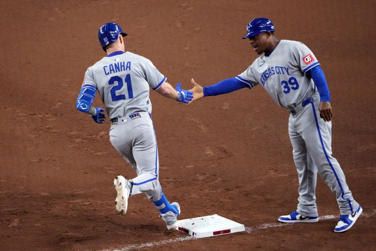 Jul 4, 2025; Phoenix, Arizona, USA; Kansas City Royals outfielder Mark Canha (21) slaps hands with Kansas City Royals first base coach Damon Hollins (39) after hitting a solo home run against the Arizona Diamondbacks during the fifth inning at Chase Field. Mandatory Credit: Joe Camporeale-Imagn Images