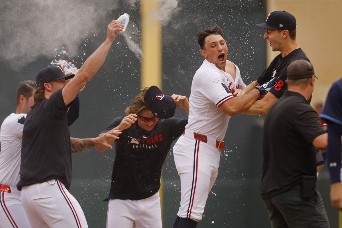 Jul 5, 2025; Minneapolis, Minnesota, USA; Teammates surround Minnesota Twins designated hitter Brooks Lee (2) after he laid down a walk-off bunt single against the Tampa Bay Rays in the ninth inning at Target Field. Mandatory Credit: Bruce Kluckhohn-Imagn Images