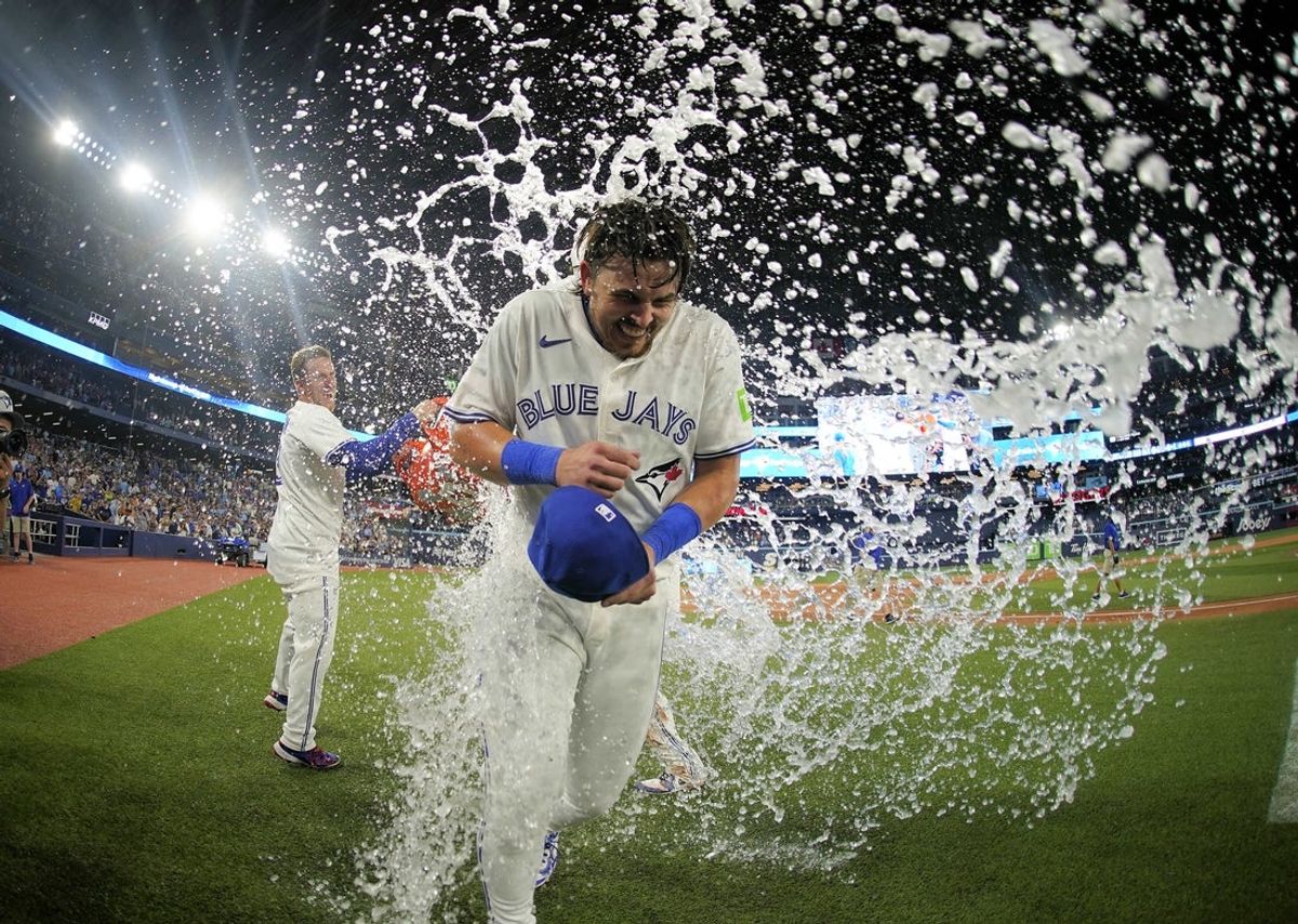 Jul 5, 2025; Toronto, Ontario, CAN; Toronto Blue Jays center fielder Myles Straw (3) throws ice water onto  right fielder Addison Barger (47) after a win over the Los Angeles Angels in the 11th inning at Rogers Centre. Mandatory Credit: John E. Sokolowski-Imagn Images
