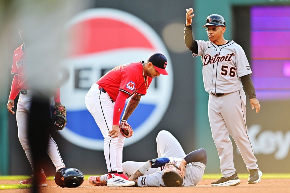 Jul 5, 2025; Cleveland, Ohio, USA; Detroit Tigers third base coach Joey Cora (56) motions to the dugout for medical personnel to come and look at second baseman Gleyber Torres (25) after Torres was injured during the first inning against the Cleveland Guardians at Progressive Field. Mandatory Credit: Ken Blaze-Imagn Images