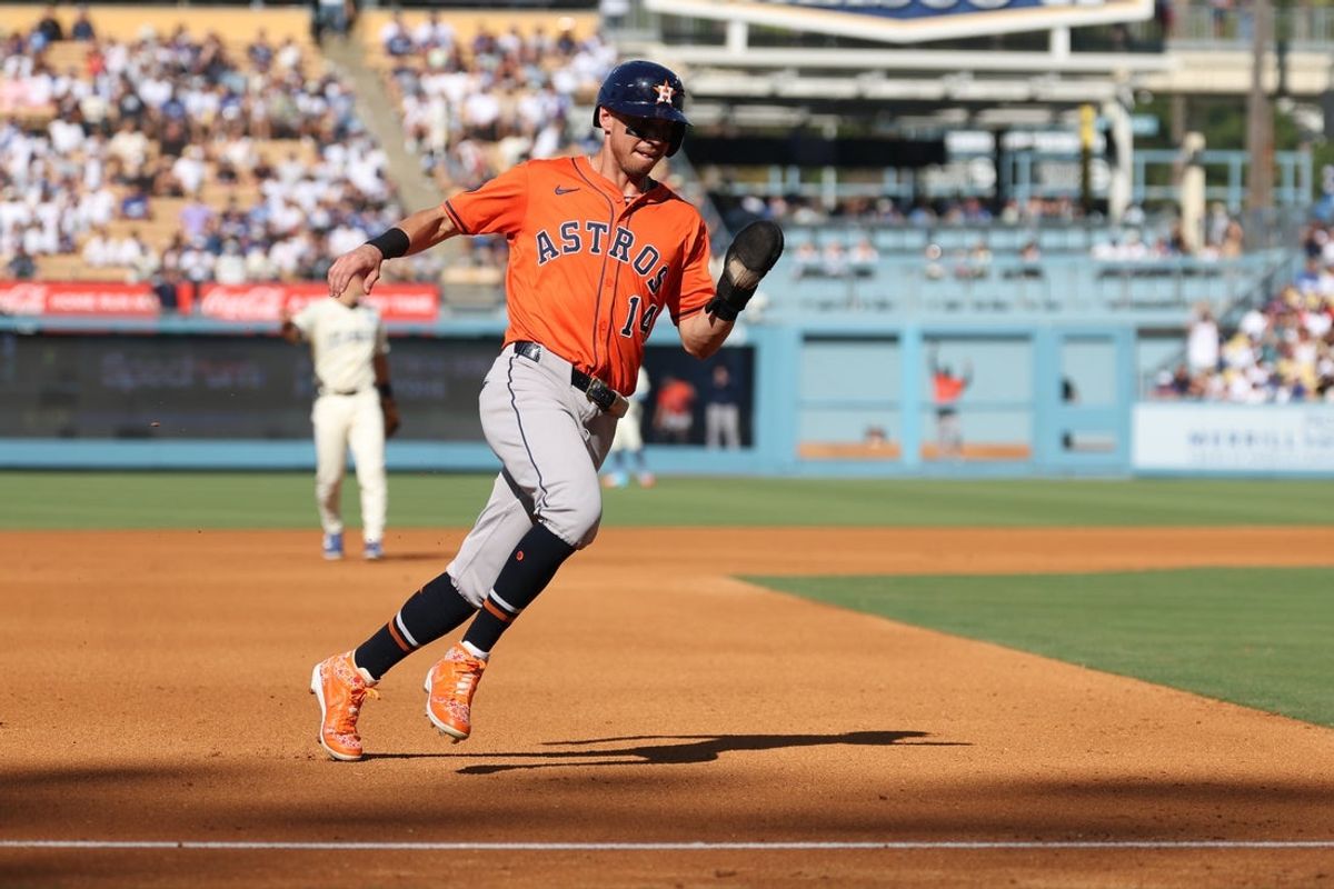 Jul 5, 2025; Los Angeles, California, USA; Houston Astros second baseman Mauricio Dubón (14) rounds third base to score during the third inning against the Los Angeles Dodgers at Dodger Stadium. Mandatory Credit: Kiyoshi Mio-Imagn Images