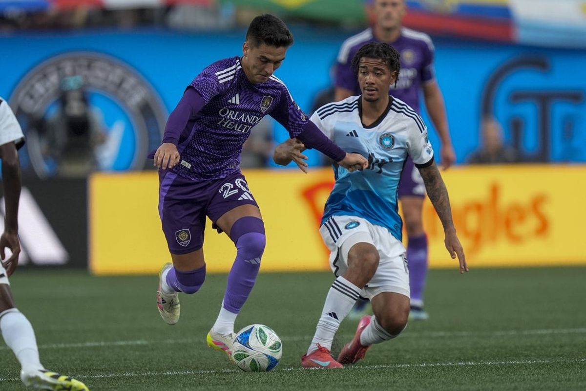 Jul 5, 2025; Charlotte, North Carolina, USA; Charlotte FC forward Idan Toklomati (17) tries to keep pressure on Orlando City midfielder Eduard Atuesta (20) during the first half at Bank of America Stadium. Mandatory Credit: Jim Dedmon-Imagn Images