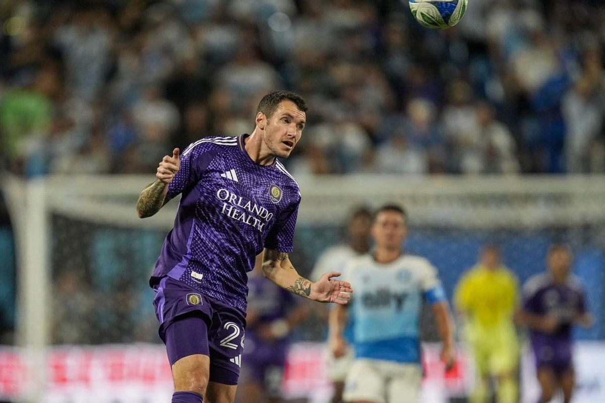 Jul 5, 2025; Charlotte, North Carolina, USA; Orlando City defender Kyle Smith (24) heads the ball to his goalie against Charlotte FC during the second half at Bank of America Stadium. Mandatory Credit: Jim Dedmon-Imagn Images