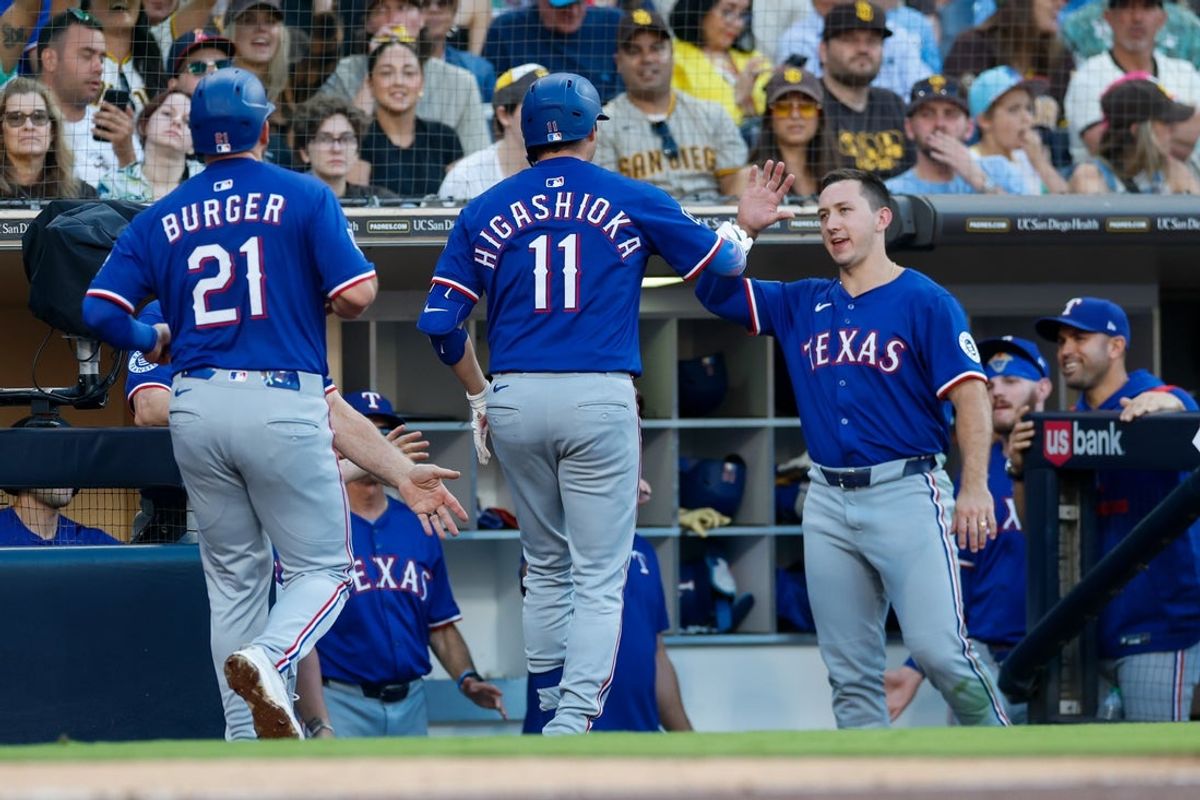 Jul 5, 2025; San Diego, California, USA; Texas Rangers catcher Kyle Higashioka (11) celebrates in the dugout after hitting a two-run home run during the third inning against the San Diego Padres at Petco Park. Mandatory Credit: David Frerker-Imagn Images
