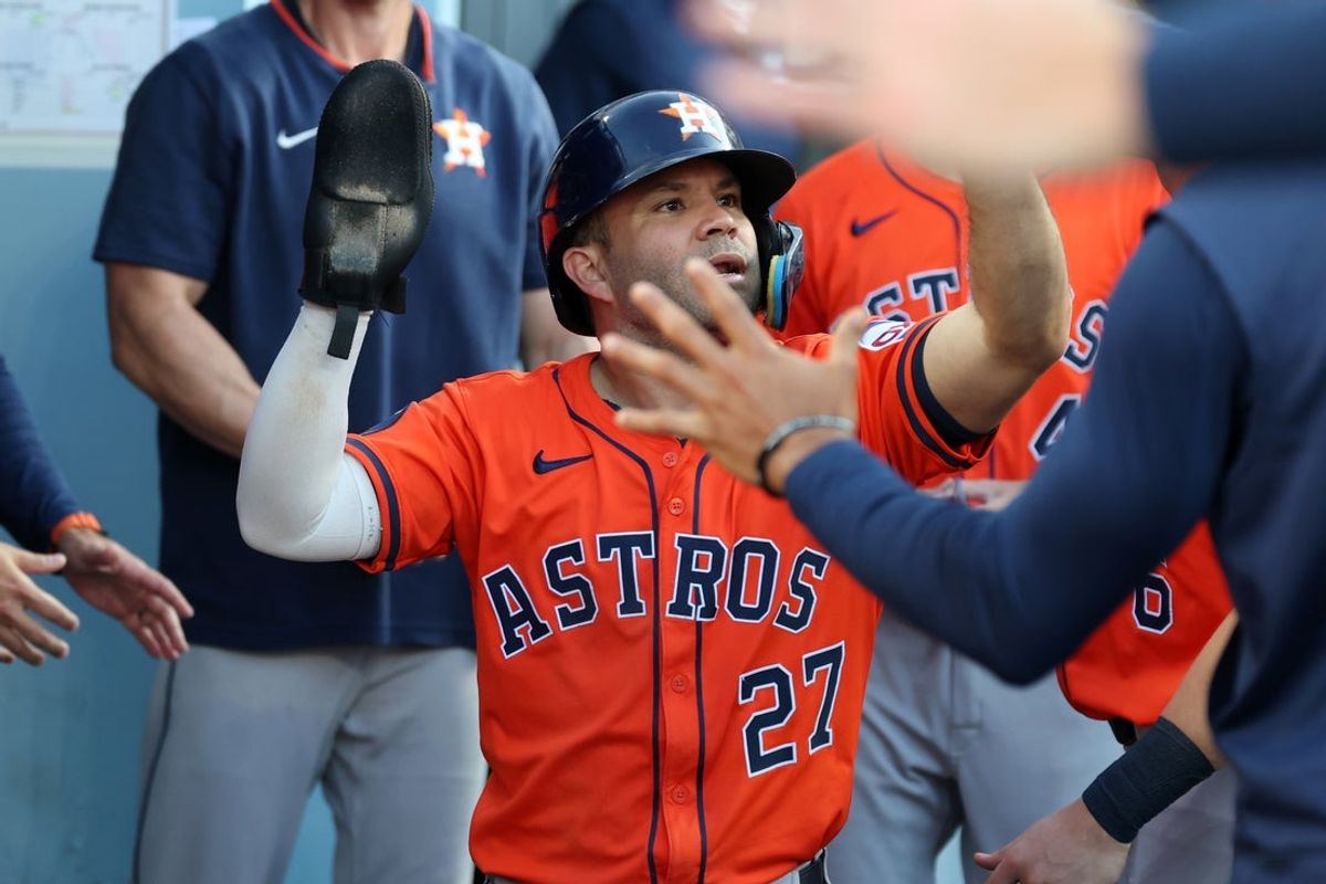 Jul 5, 2025; Los Angeles, California, USA;  Houston Astros second baseman Jose Altuve (27) is greeted in the dugout after scoring a run during the eighth inning against the Los Angeles Dodgers at Dodger Stadium. Mandatory Credit: Kiyoshi Mio-Imagn Images