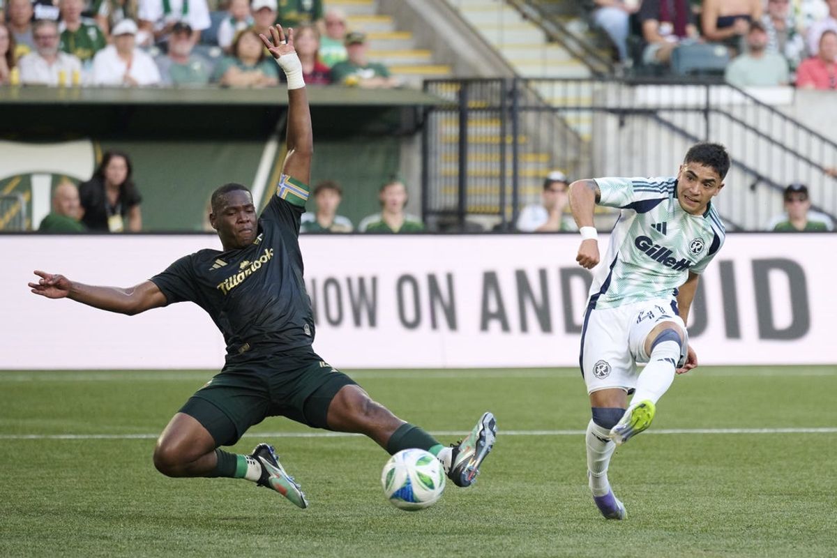 Jul 5, 2025; Portland, Oregon, USA;  New England Revolution forward Luca Langoni (41) scores a goal in the first half against Portland Timbers defender Kamal Miller (4) at Providence Park. Mandatory Credit: Troy Wayrynen-Imagn Images