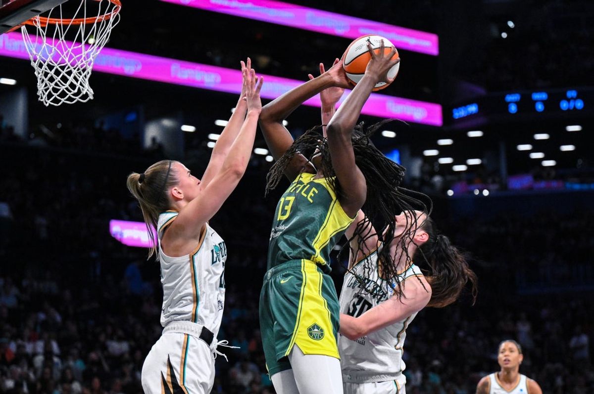 Jul 6, 2025; Brooklyn, New York, USA; Seattle Storm forward Ezi Magbegor (13) shoots the ball while being defended by New York Liberty guard Sabrina Ionescu (20) and forward Breanna Stewart (30) during the first half at Barclays Center. Mandatory Credit: John Jones-Imagn Images