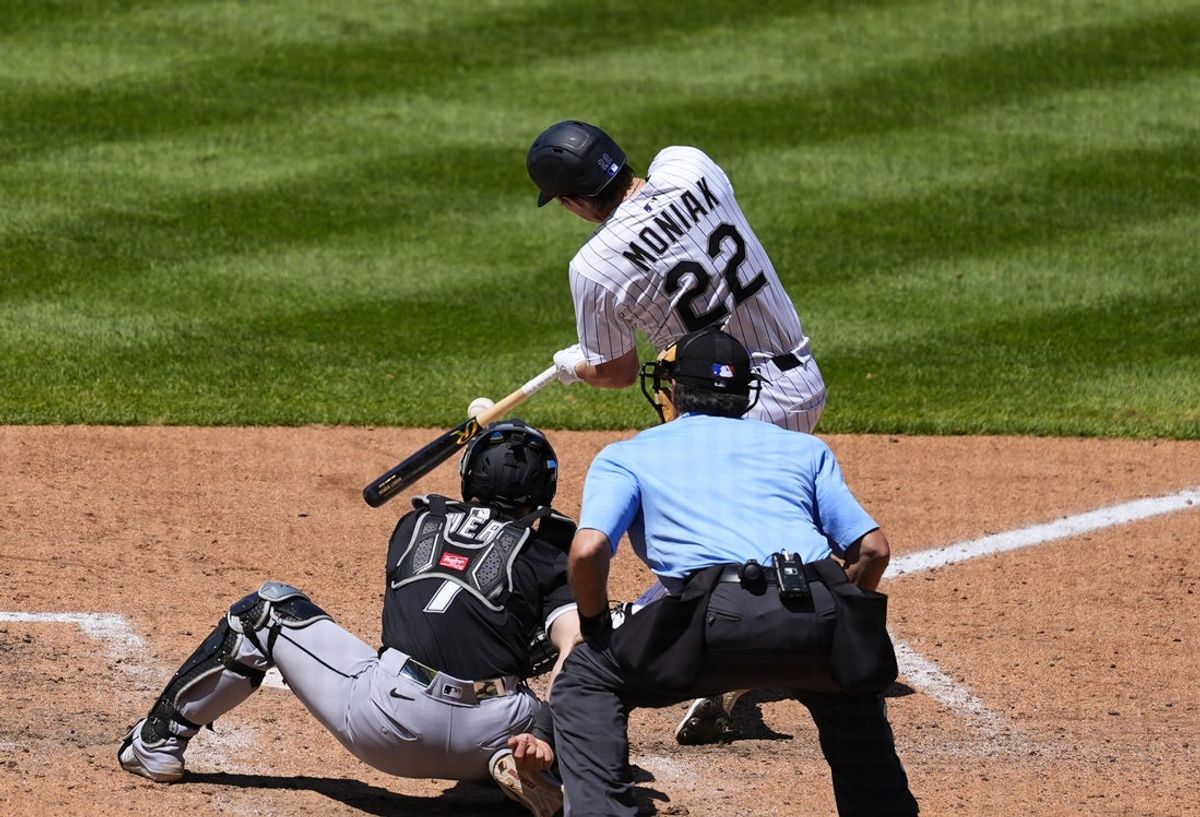 Jul 6, 2025; Denver, Colorado, USA; Colorado Rockies center fielder Mickey Moniak (22) hits a two run triple in the fifth inning against the Chicago White Sox at Coors Field. Mandatory Credit: Ron Chenoy-Imagn Images