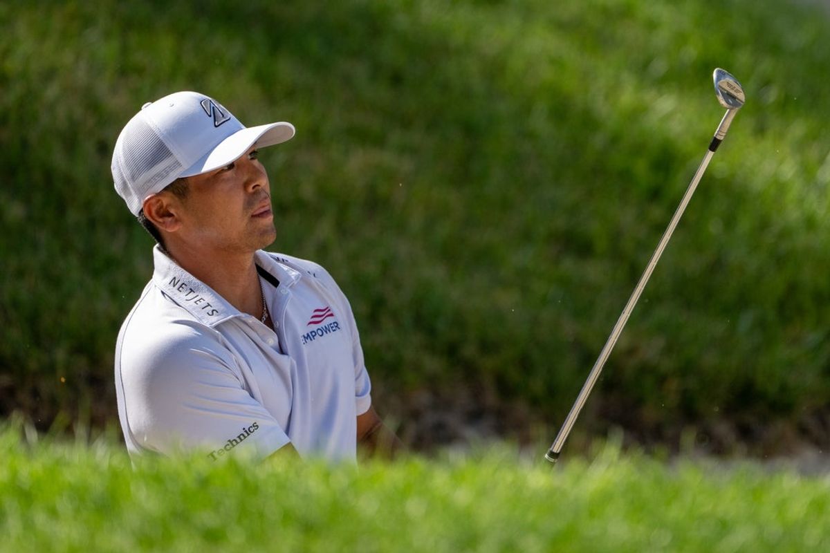 Jul 6, 2025; Silvis, Illinois, USA; Kurt Kitayama reacts to hitting a shot out of the bunker on the 18th hole during the final round of the John Deere Classic golf tournament. Mandatory Credit: Marc Lebryk-Imagn Images
