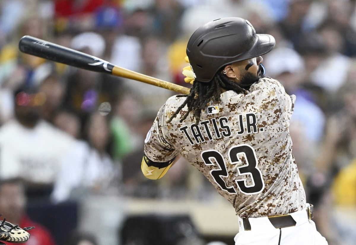 Jul 6, 2025; San Diego, California, USA; San Diego Padres right fielder Fernando Tatis Jr. (23) hits an RBI double during the fourth inning against the Texas Rangers at Petco Park. Mandatory Credit: Denis Poroy-Imagn Images