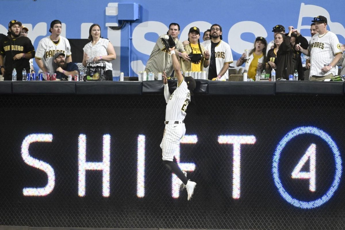 Jul 8, 2025; San Diego, California, USA; San Diego Padres right fielder Fernando Tatis Jr. (23) makes a catch at the wall on a hit by Arizona Diamondbacks first baseman Josh Naylor (22) during the eighth inning at Petco Park. Mandatory Credit: Denis Poroy-Imagn Images