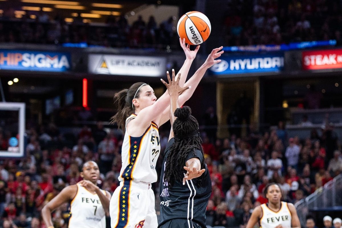 Jul 9, 2025; Indianapolis, Indiana, USA; Indiana Fever guard Caitlin Clark (22) shoots the ball while  Golden State Valkyries guard Tiffany Hayes (15) defends in the first half at Gainbridge Fieldhouse. Mandatory Credit: Trevor Ruszkowski-Imagn Images