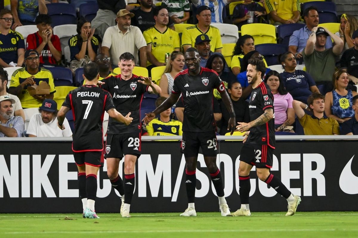 Jul 9, 2025; Nashville, Tennessee, USA;  D.C. United forward Christian Benteke (20) celebrates scoring with teammates against the Nashville SC during the first half at GEODIS Park. Mandatory Credit: Steve Roberts-Imagn Images