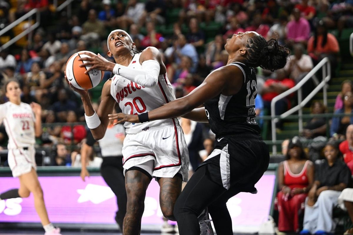 Jul 10, 2025; Washington, District of Columbia, USA; Las Vegas Aces guard Chelsea Gray (12) is called for a blocking foul against Washington Mystics guard Brittney Sykes (20) during the second quarter at EagleBank Arena. Mandatory Credit: Rafael Suanes-Imagn Images
