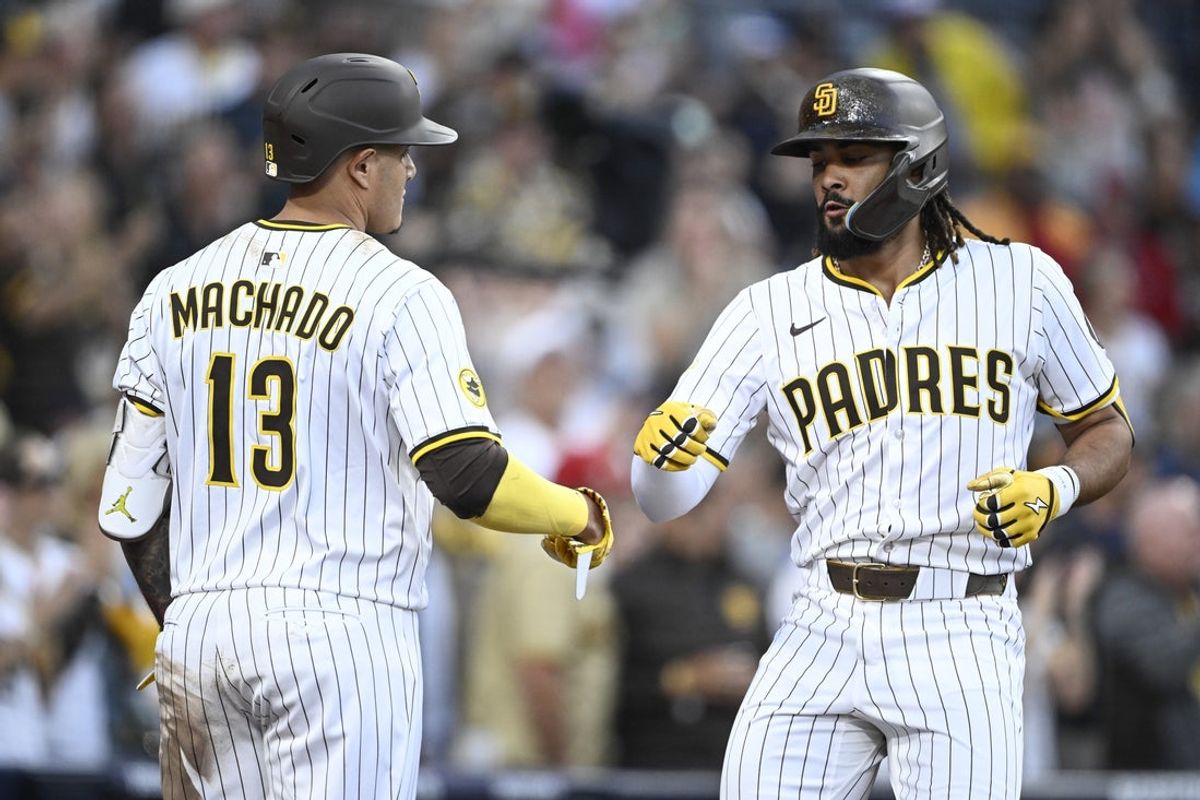 Jul 10, 2025; San Diego, California, USA; San Diego Padres right fielder Fernando Tatis Jr. (23) is congratulated by  Manny Machado (13) after hitting a solo home run during the third inning against the Arizona Diamondbacks at Petco Park. Mandatory Credit: Denis Poroy-Imagn Images a