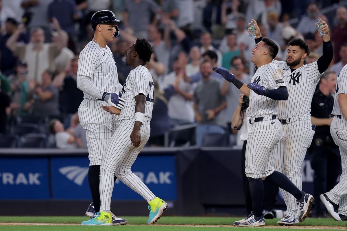 Jul 10, 2025; Bronx, New York, USA; New York Yankees designated hitter Aaron Judge (99) celebrates with second baseman Jazz Chisholm Jr. (13) and shortstop Anthony Volpe (11) and left fielder Jasson Dominguez (24) after his tenth inning walkoff sacrifice fly against the Seattle Mariners at Yankee Stadium. Mandatory Credit: Brad Penner-Imagn Images